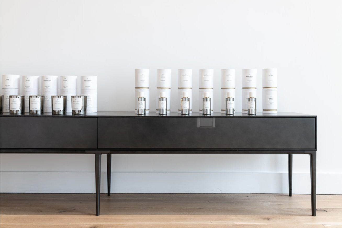 JANGEORGe Interior Design & Furniture, a Long black table with multiple silver and white containers against a white wall.